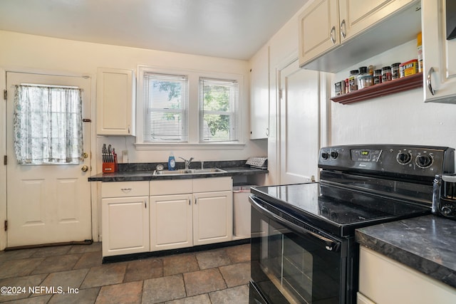 kitchen with white cabinetry, a wealth of natural light, electric range, and sink