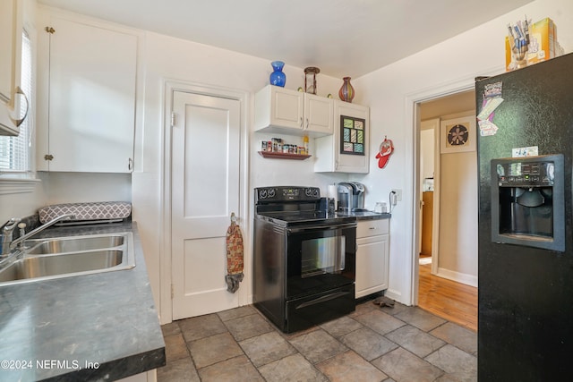 kitchen featuring black appliances, white cabinetry, and sink