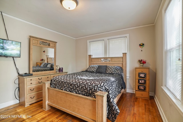 bedroom with hardwood / wood-style flooring and crown molding