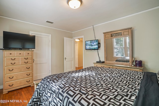 bedroom featuring crown molding and dark hardwood / wood-style floors