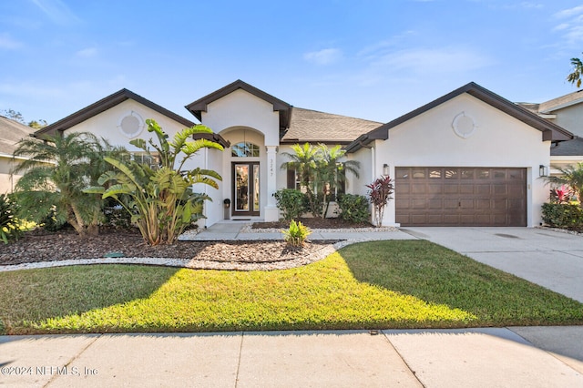 view of front of property with a garage and a front lawn