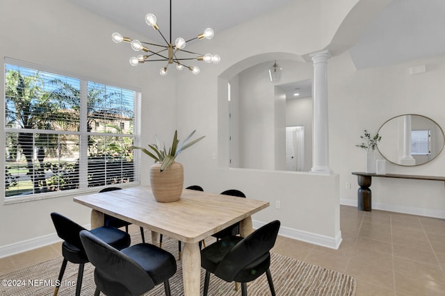 dining space with decorative columns, light tile patterned flooring, and a chandelier