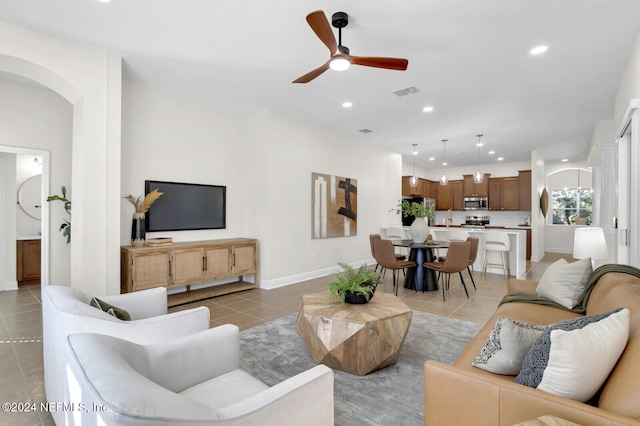 living room featuring light tile patterned floors and ceiling fan