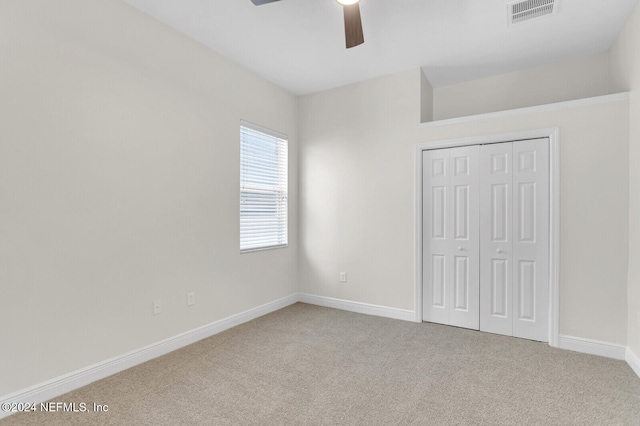 unfurnished bedroom with carpet floors, a closet, and ceiling fan