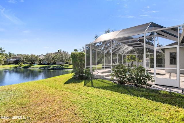 view of yard with a lanai and a water view