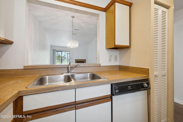 kitchen featuring an inviting chandelier, white cabinets, sink, hanging light fixtures, and dishwashing machine