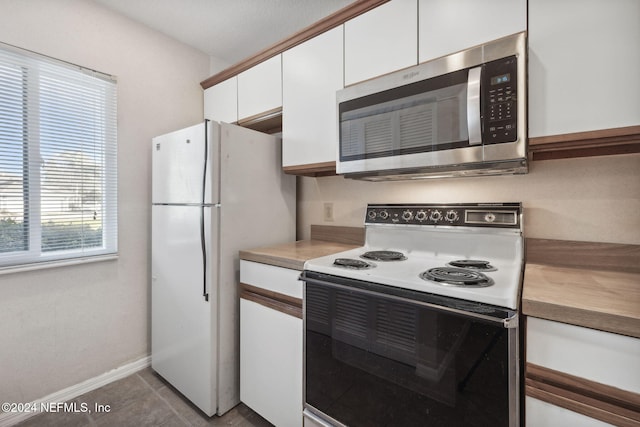 kitchen with tile patterned floors, white cabinets, and white appliances