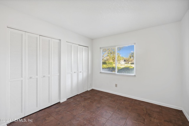 unfurnished bedroom with two closets