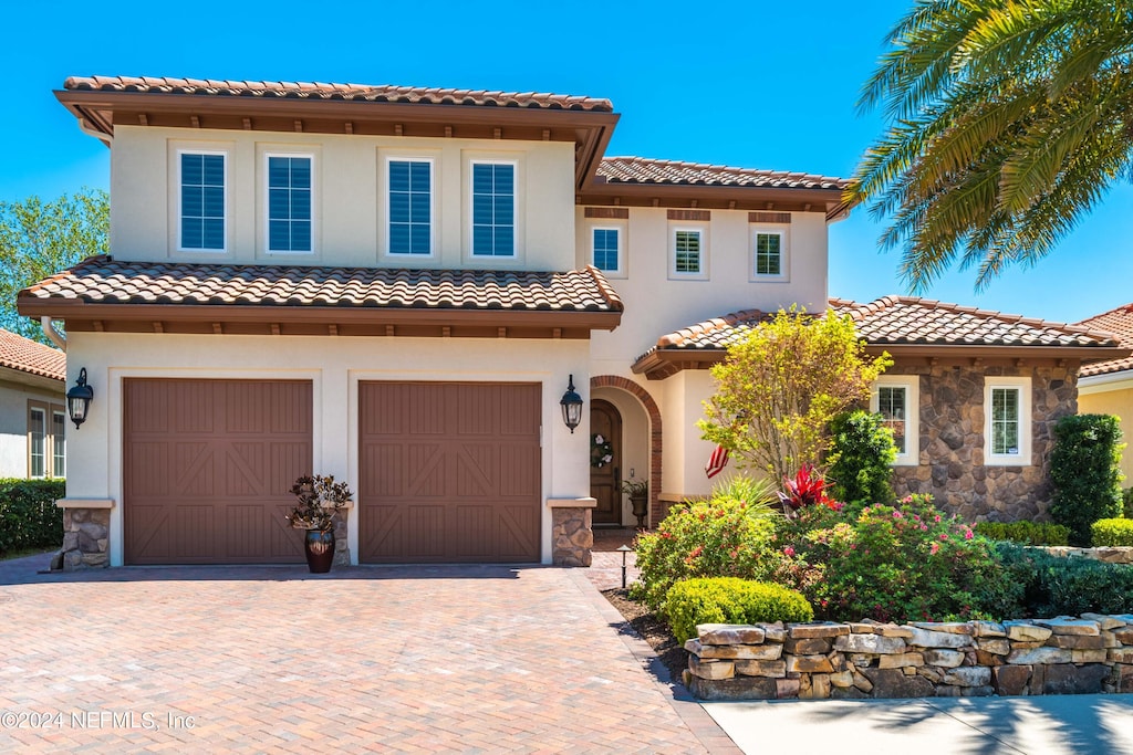 mediterranean / spanish home with a garage