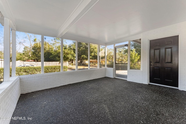 unfurnished sunroom with beamed ceiling