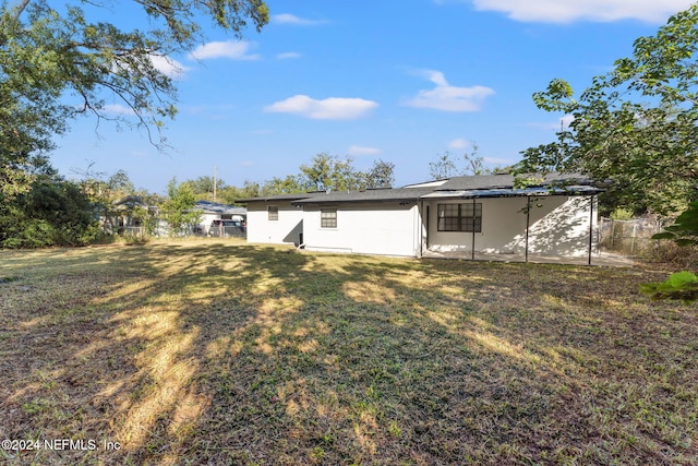 rear view of property with a lawn