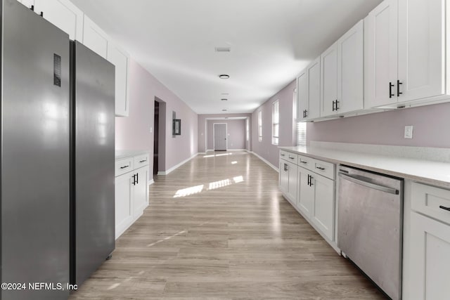 kitchen with white cabinetry, stainless steel appliances, and light wood-type flooring