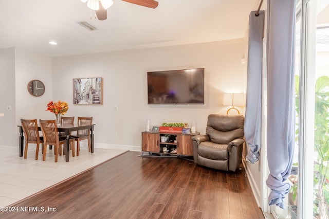 living room with ceiling fan, wood-type flooring, ornamental molding, and a wealth of natural light