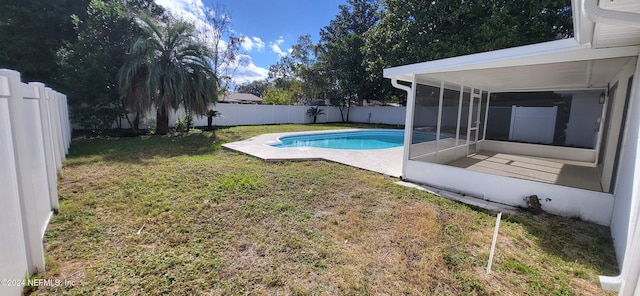 view of pool featuring a lawn and a sunroom