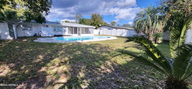 view of pool with a lawn