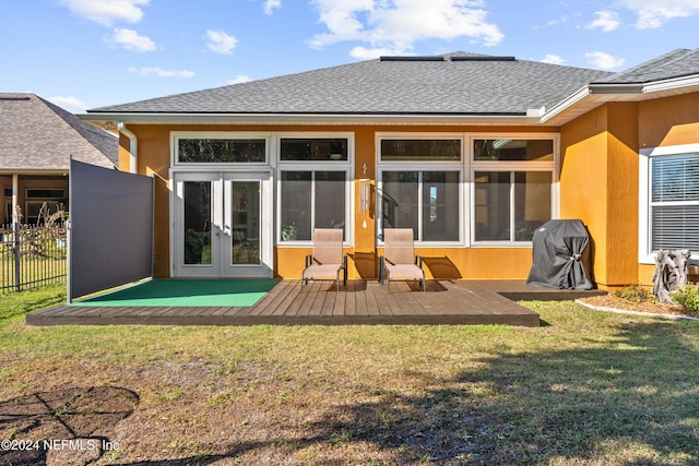 back of house featuring a yard, a wooden deck, and french doors