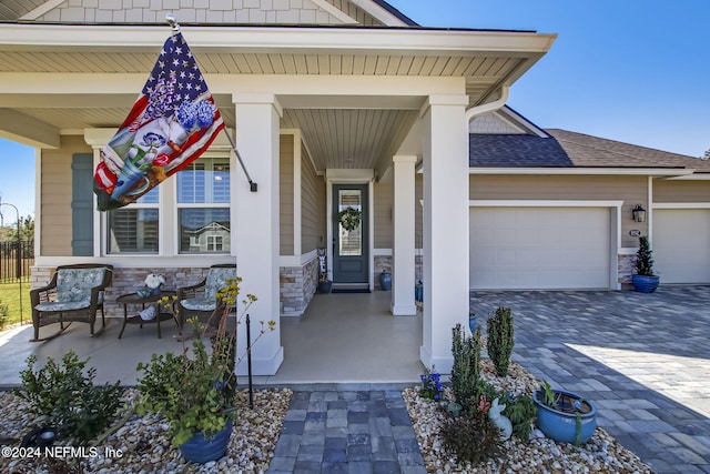 entrance to property with covered porch and a garage