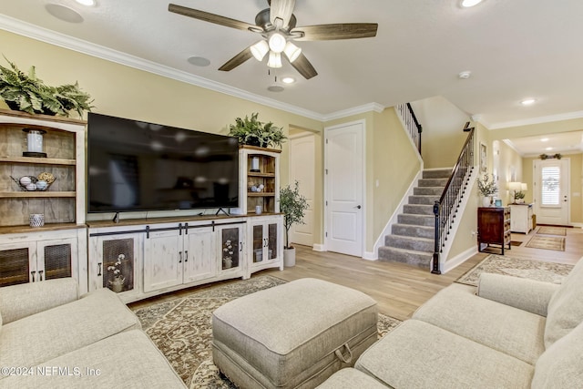 living room with hardwood / wood-style flooring, ceiling fan, and ornamental molding