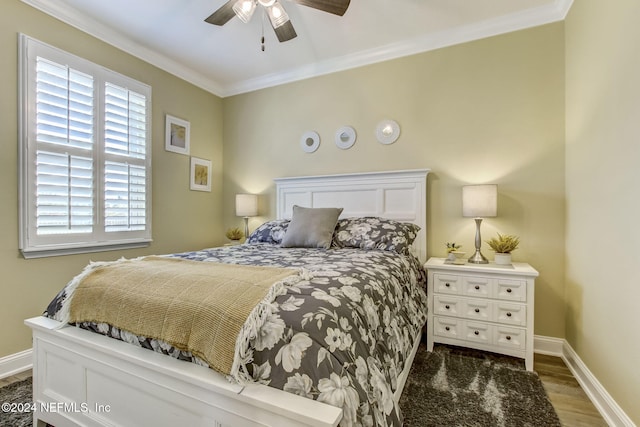 bedroom featuring dark hardwood / wood-style flooring, ceiling fan, and crown molding