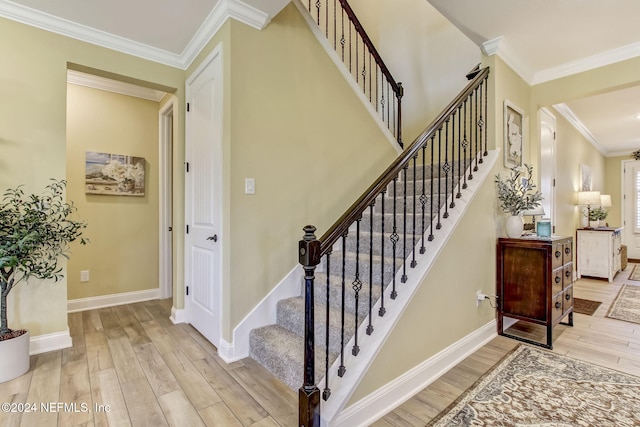 stairs featuring ornamental molding and hardwood / wood-style flooring