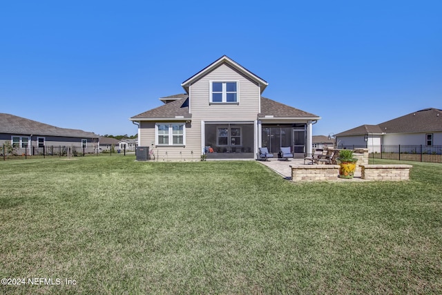 rear view of property with a sunroom, cooling unit, a patio area, and a lawn