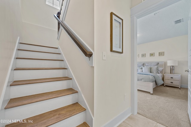 staircase featuring carpet