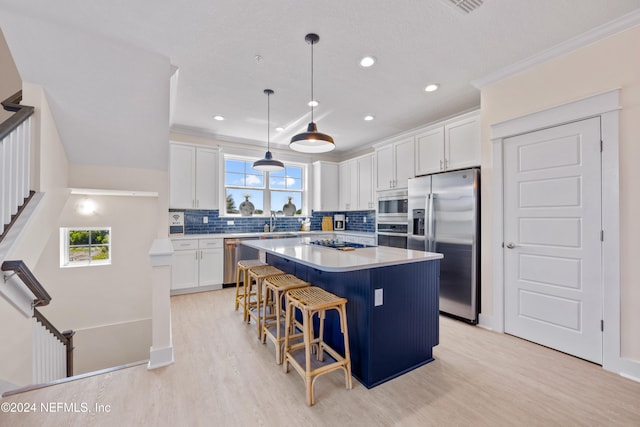 kitchen featuring white cabinetry, a kitchen island, light hardwood / wood-style floors, and appliances with stainless steel finishes