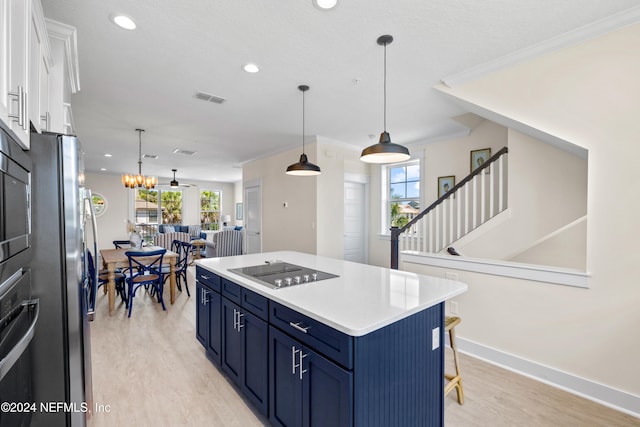 kitchen with blue cabinetry, decorative light fixtures, stainless steel appliances, and white cabinetry