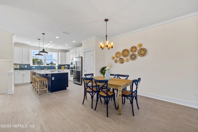 dining space with a chandelier, sink, light hardwood / wood-style floors, and ornamental molding