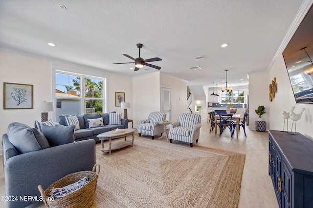 living room featuring ornamental molding, a textured ceiling, and a healthy amount of sunlight