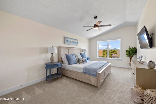 bedroom featuring a textured ceiling, ceiling fan, light colored carpet, and vaulted ceiling