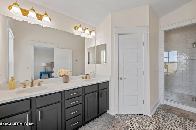 bathroom featuring tile patterned flooring, vanity, walk in shower, and lofted ceiling