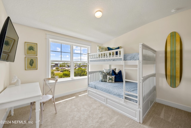 bedroom featuring light colored carpet and a textured ceiling