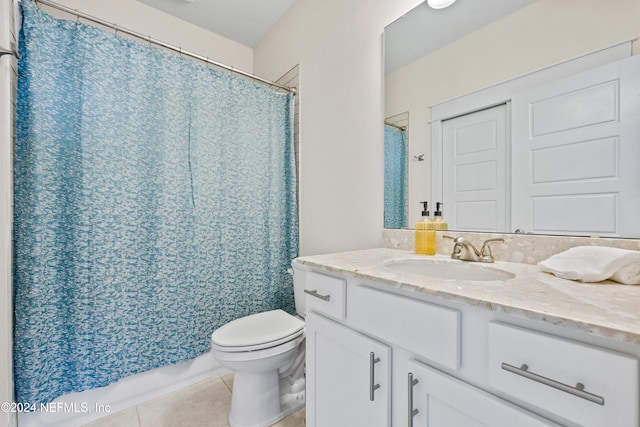 bathroom with toilet, vanity, and tile patterned floors