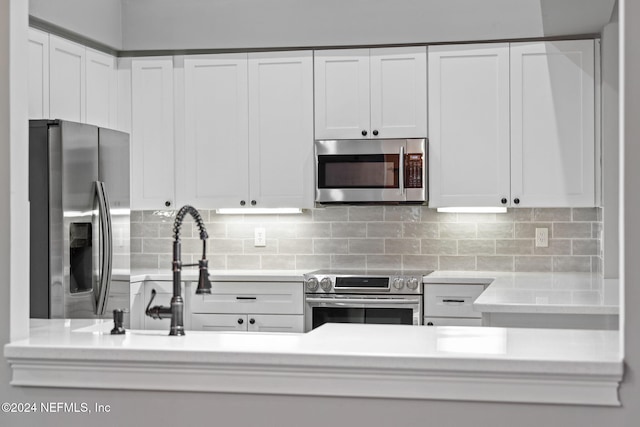 kitchen featuring appliances with stainless steel finishes, tasteful backsplash, and white cabinetry