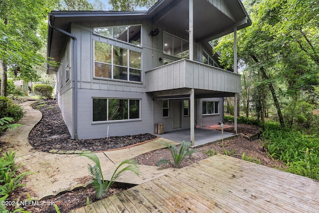 back of property featuring a balcony, a patio area, and a wooden deck