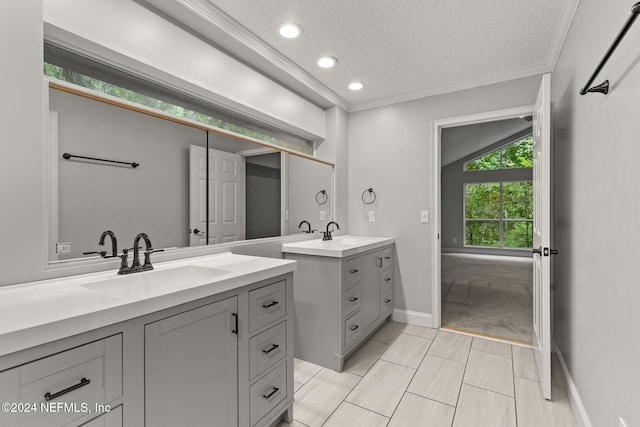 bathroom with tile patterned floors, crown molding, lofted ceiling, a textured ceiling, and vanity