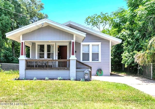 bungalow with a front lawn and covered porch