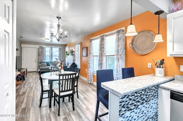 dining space with a notable chandelier and light hardwood / wood-style floors