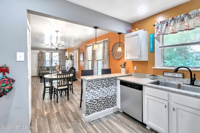 kitchen with sink, hanging light fixtures, stainless steel dishwasher, white cabinets, and light wood-type flooring