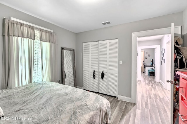 bedroom with light hardwood / wood-style floors and a closet