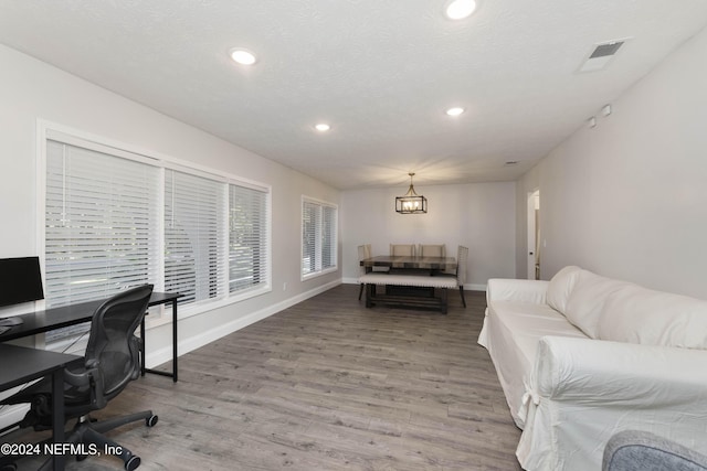 home office with hardwood / wood-style flooring, a notable chandelier, and a textured ceiling