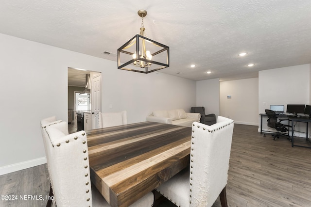 dining room featuring a notable chandelier, a textured ceiling, and dark hardwood / wood-style flooring