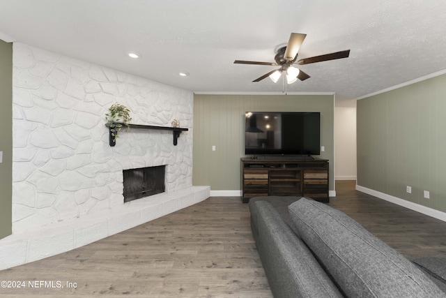 living room featuring ceiling fan, hardwood / wood-style floors, a textured ceiling, and a fireplace