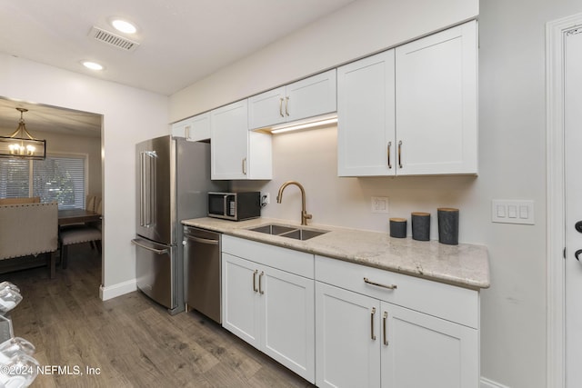 kitchen with stainless steel appliances, white cabinetry, sink, and dark wood-type flooring