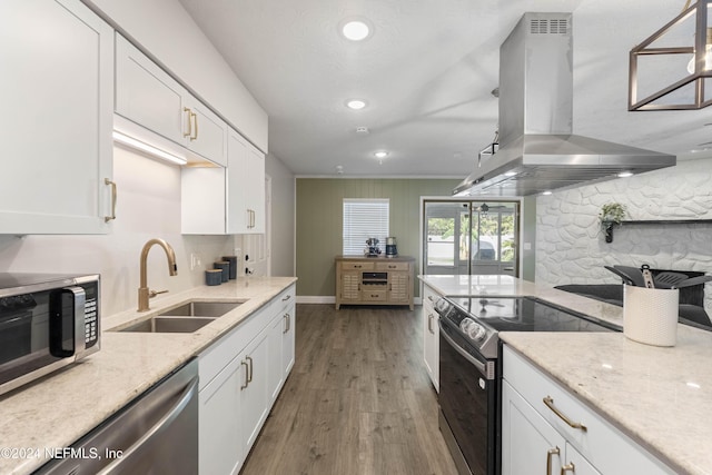 kitchen featuring island range hood, decorative light fixtures, white cabinetry, sink, and stainless steel appliances