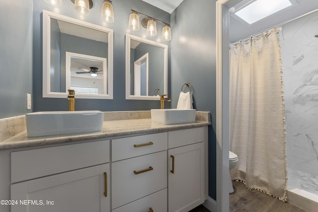 bathroom with vanity, toilet, curtained shower, and wood-type flooring