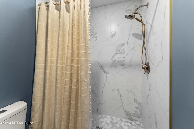 bathroom featuring tiled shower and toilet