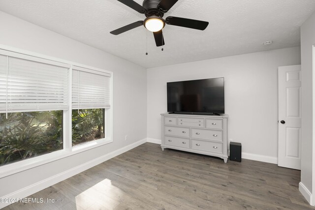 unfurnished bedroom with ceiling fan, hardwood / wood-style floors, and a textured ceiling