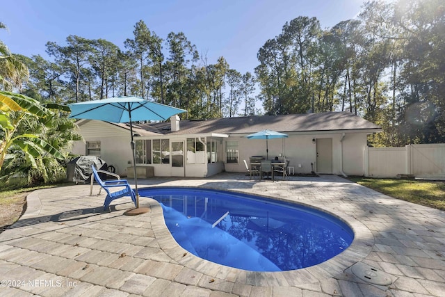 view of pool with a patio area and a sunroom